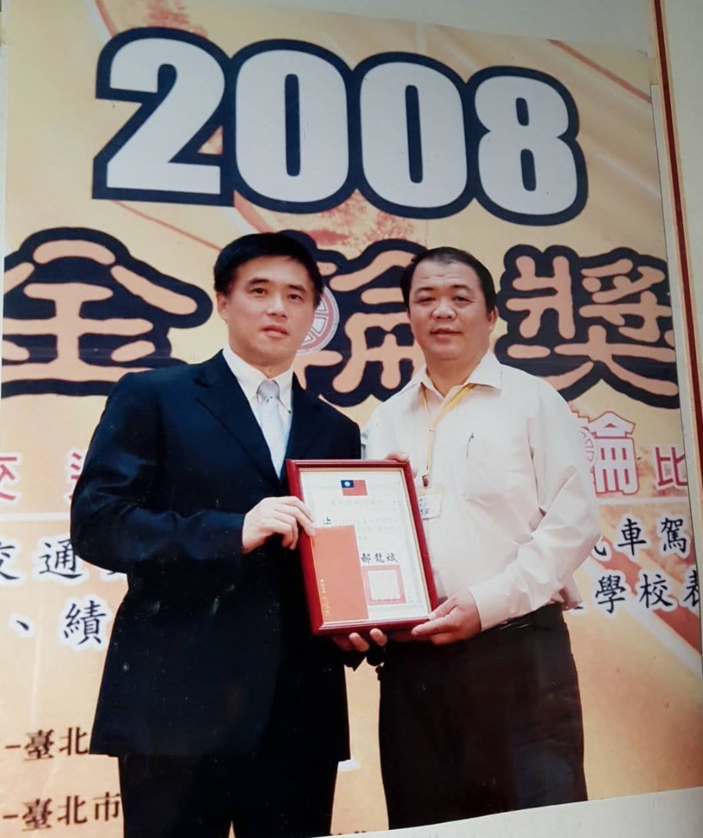 范添美曾多次榮獲表揚優良職業駕駛人的金輪獎肯定，左為時任台北市長郝龍斌。（范添美提供）