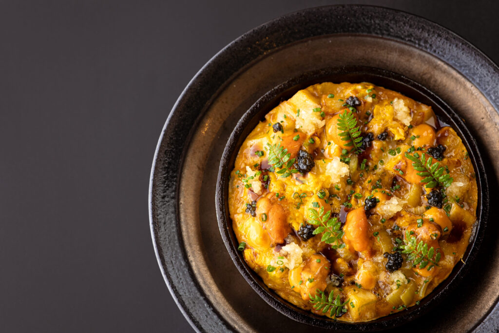 「北海道海膽烘蛋」將微脆鬆軟的馬鈴薯與雞蛋做結合，再放上日本根室海膽、法國魚子醬相融，可以吃得到烘蛋的脆香及海鮮的絲滑鮮甜。（飛花落院提供）